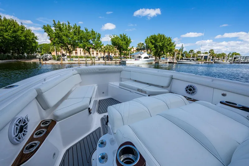  Yacht Photos Pics Luxurious 2020 Everglades 395 Center Console boat interior with white seating, docked by a marina.