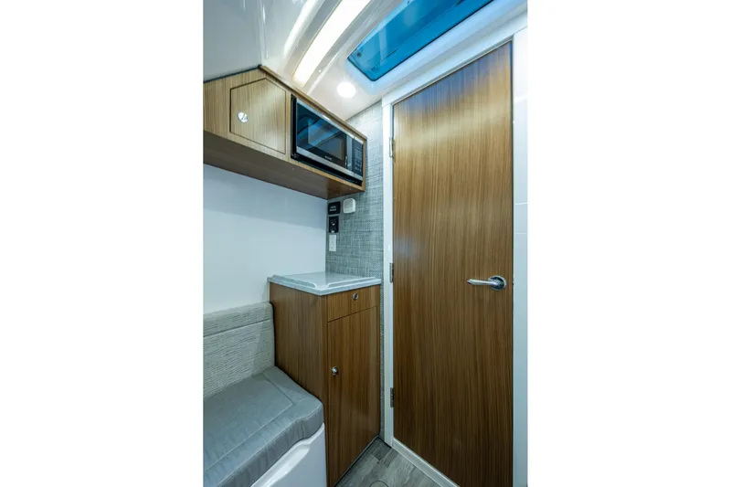  Yacht Photos Pics Interior of 2020 Everglades 395 Center Console with microwave and wooden cabinetry.