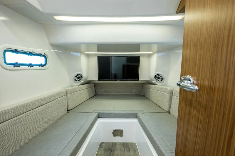  Yacht Photos Pics 2020 Everglades 395 Center Console cabin interior with seating, TV, and porthole window.