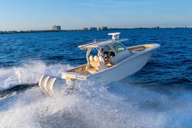  Yacht Photos Pics 2020 Scout 355 LXF boat cruising on open water, creating a dynamic wake.
