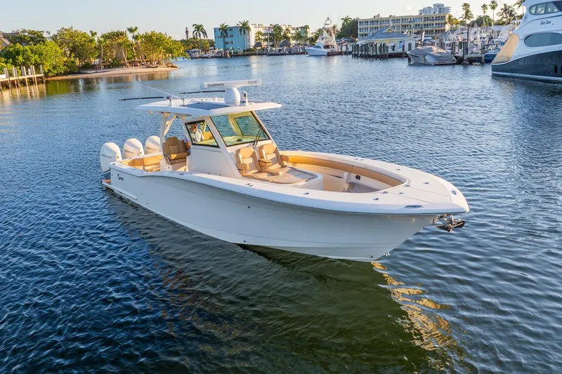  Yacht Photos Pics 2020 Scout 355 LXF boat on calm water, surrounded by marina and palm trees.