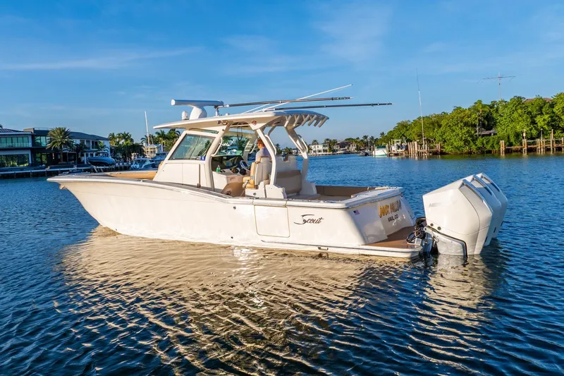  Yacht Photos Pics 2020 Scout 355 LXF boat on calm water, sunny day, waterfront homes in background.