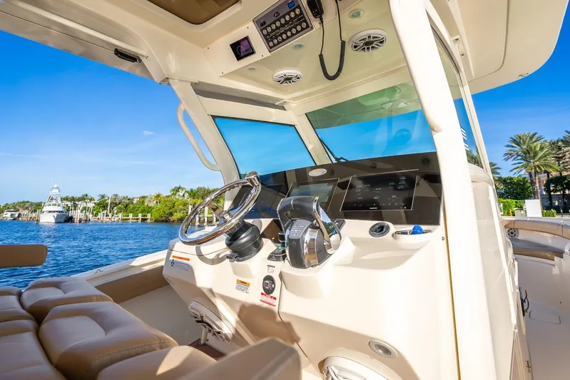  Yacht Photos Pics 2020 Scout 355 LXF boat cockpit with modern controls and scenic waterfront view.