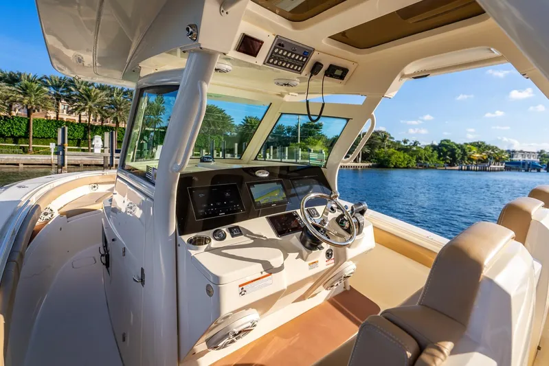  Yacht Photos Pics 2020 Scout 355 LXF boat interior with helm, steering wheel, and navigation screens.