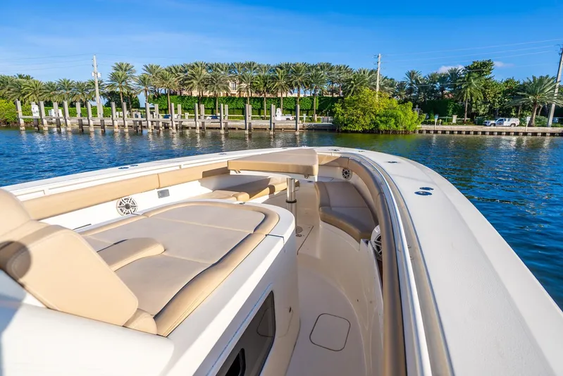 Yacht Photos Pics 2020 Scout 355 LXF boat with luxurious seating, dockside view, and palm trees in the background.