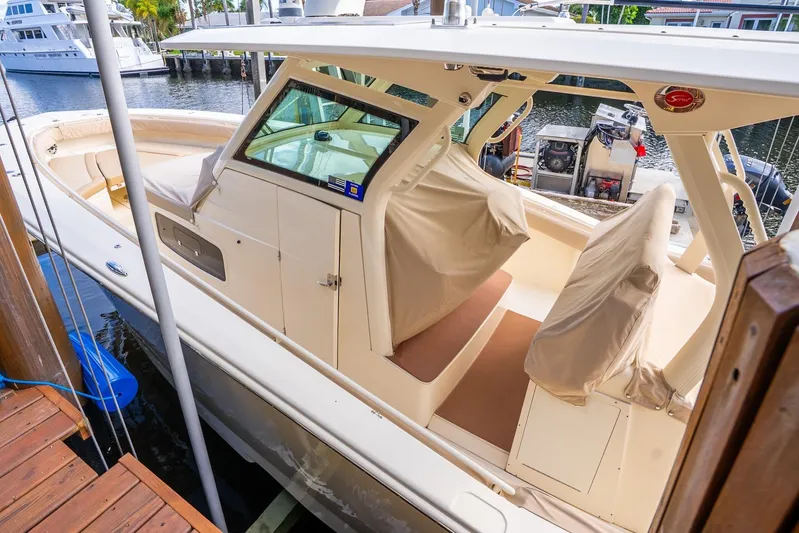  Yacht Photos Pics 2020 Scout 355 LXF boat docked, featuring covered seating and sleek design.