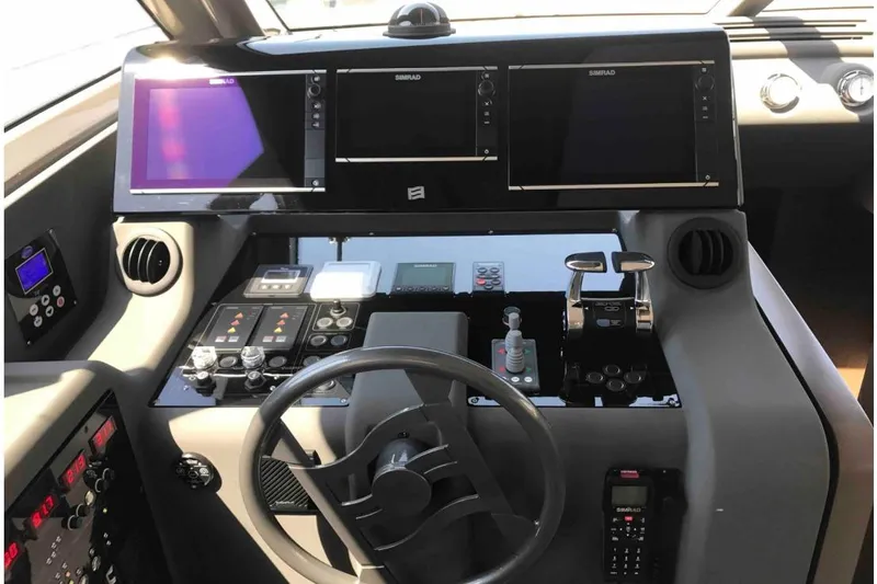  Yacht Photos Pics Control panel of a 2017 Ferreti 550 yacht with navigation screens and steering wheel.