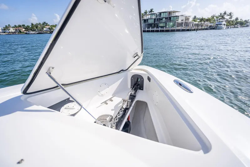  Yacht Photos Pics 2018 Nor-Tech 390 boat with open storage compartment, docked near waterfront homes.