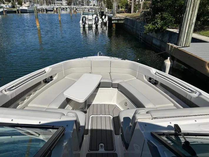  Yacht Photos Pics 2023 Sea Ray SLX 310 OB boat with spacious seating and table, docked in a marina.