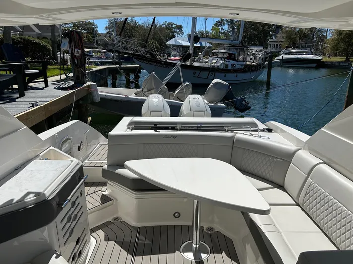  Yacht Photos Pics 2023 Sea Ray SLX 310 OB boat interior with seating and table, docked at marina.