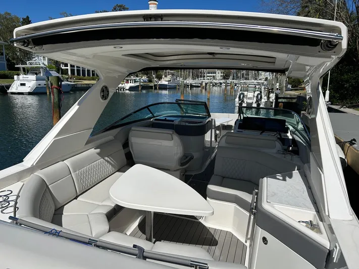  Yacht Photos Pics 2023 Sea Ray SLX 310 OB boat interior with seating and table, docked at marina.