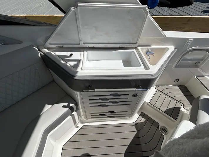  Yacht Photos Pics 2023 Sea Ray SLX 310 OB boat interior with open storage compartment and seating area.