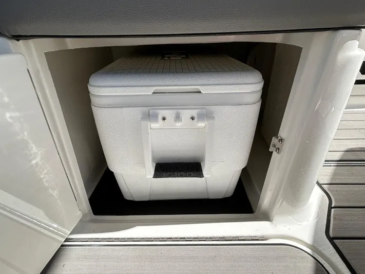  Yacht Photos Pics 2023 Sea Ray SLX 310 OB cooler storage compartment with white cooler inside.