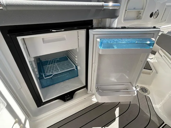  Yacht Photos Pics 2023 Sea Ray SLX 310 OB boat refrigerator, open with visible shelving and storage.