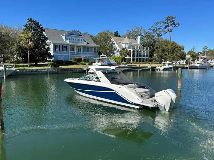  Yacht Photos Pics 2023 Sea Ray SLX 310 OB boat docked in a scenic waterfront setting.