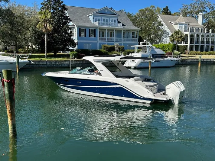  Yacht Photos Pics 2023 Sea Ray SLX 310 OB boat cruising in a scenic waterfront setting.