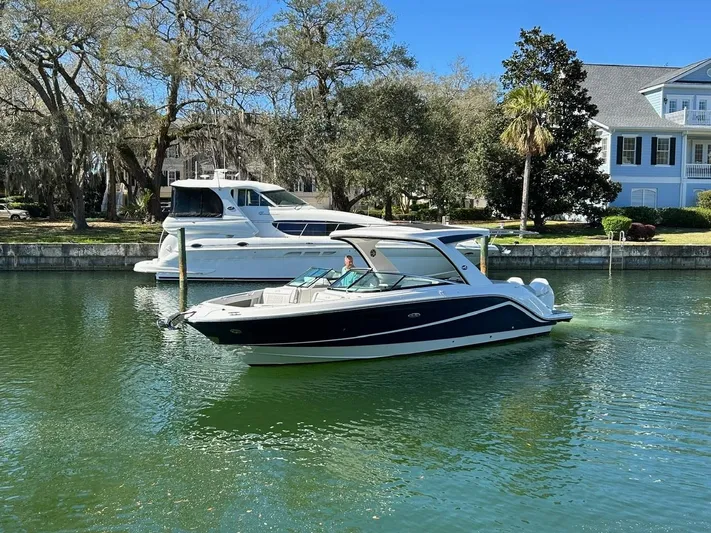  Yacht Photos Pics 2023 Sea Ray SLX 310 OB boat cruising on a calm, scenic waterway.