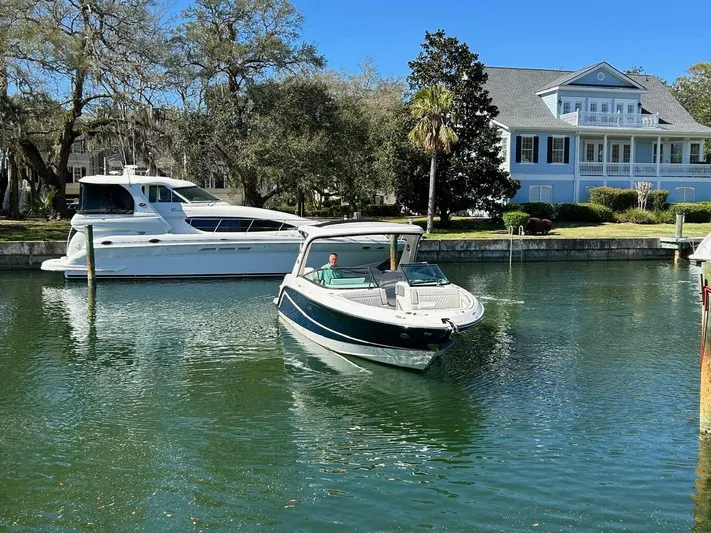  Yacht Photos Pics 2023 Sea Ray SLX 310 OB boat cruising near waterfront homes.