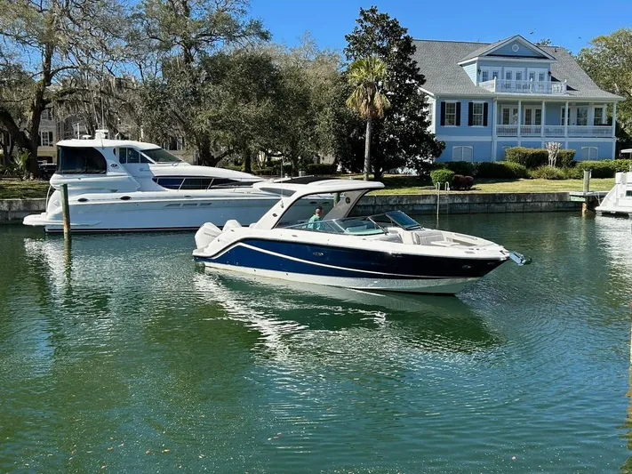  Yacht Photos Pics 2023 Sea Ray SLX 310 OB boat docked near a waterfront house.