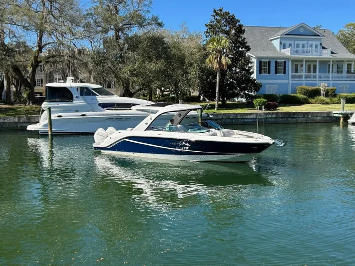  Yacht Photos Pics 2023 Sea Ray SLX 310 OB boat docked near waterfront home, sunny day.