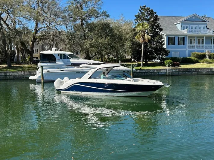  Yacht Photos Pics 2023 Sea Ray SLX 310 OB boat docked in a serene waterfront setting.