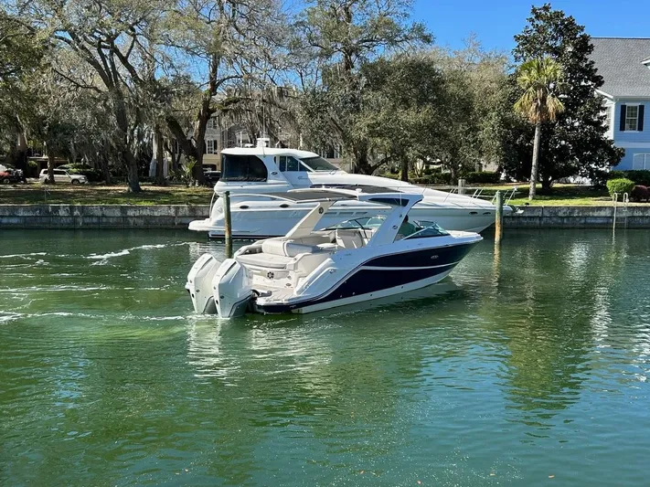  Yacht Photos Pics 2023 Sea Ray SLX 310 OB boat cruising on a calm, scenic waterway.