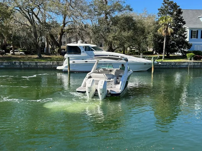  Yacht Photos Pics 2023 Sea Ray SLX 310 OB boat cruising in a serene canal setting.