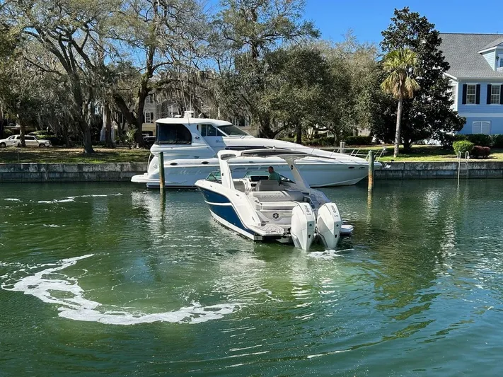  Yacht Photos Pics 2023 Sea Ray SLX 310 OB boat in a serene marina setting.