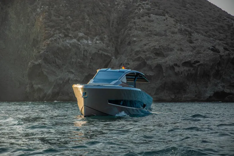  Yacht Photos Pics 2025 Tesoro T50 Armani Casa Speciale yacht cruising near rocky coastline.