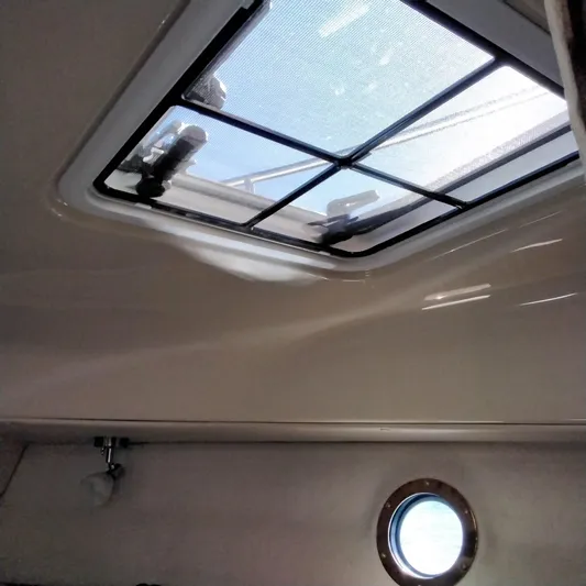  Yacht Photos Pics Interior view of 2023 Ranger Tugs R-25 cabin with skylight and porthole.