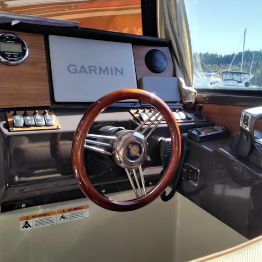  Yacht Photos Pics 2023 Ranger Tugs R-25 helm with Garmin navigation system and wooden steering wheel.
