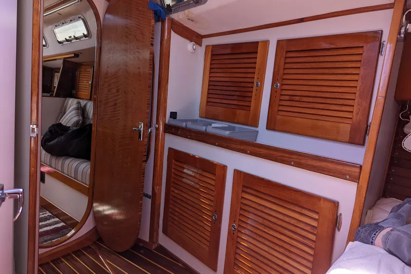 Ardent Yacht Photos Pics Interior of 1993 J Boats J/130 sailboat with wooden cabinetry and striped seating.