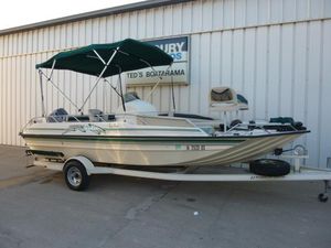 2000 SeaArk Sunstar 21 boat with canopy on trailer, parked outside a building.