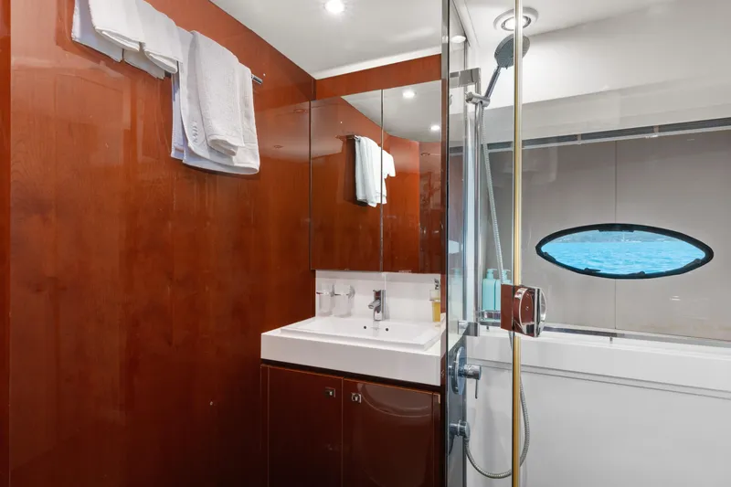 About Time Yacht Photos Pics Luxurious bathroom on 2014 Princess Flybridge 72 Motor Yacht with wood paneling and modern fixtures.