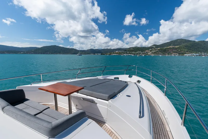 About Time Yacht Photos Pics Luxurious 2014 Princess Flybridge 72 Motor Yacht on serene blue waters, scenic mountain backdrop.