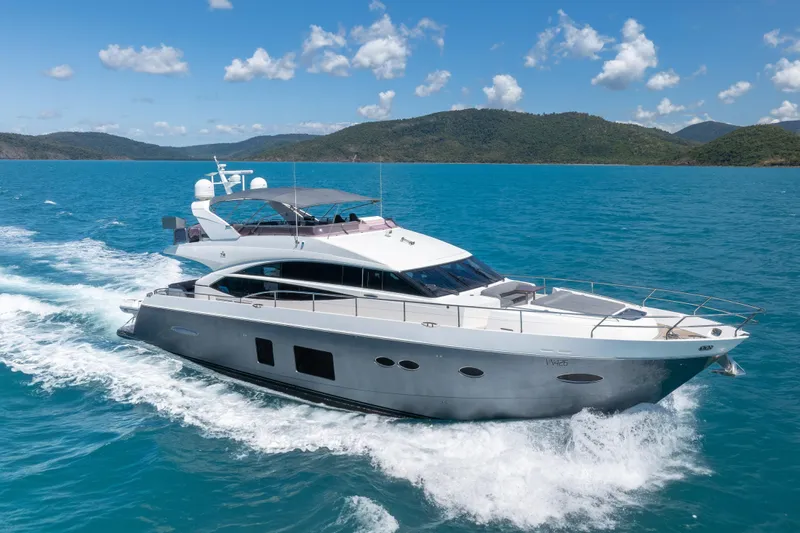 About Time Yacht Photos Pics 2014 Princess Flybridge 72 Motor Yacht cruising on blue ocean with scenic island backdrop.