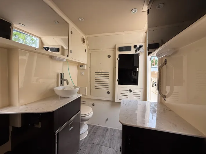  Yacht Photos Pics Luxurious bathroom interior of 2020 Scout 355 LXF boat with modern fixtures and cabinetry.