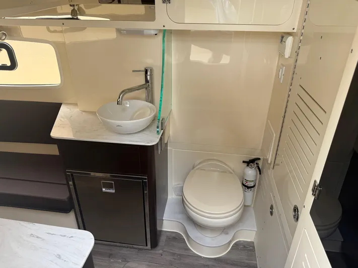  Yacht Photos Pics 2020 Scout 355 LXF boat interior with sink, toilet, and storage cabinets.