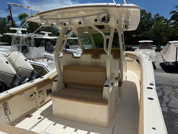  Yacht Photos Pics 2020 Scout 355 LXF boat interior with seating and helm, docked among other boats.