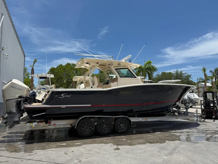  Yacht Photos Pics 2020 Scout 355 LXF boat on trailer, parked outdoors under clear blue sky.