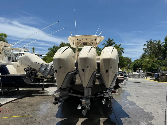  Yacht Photos Pics 2020 Scout 355 LXF boat with triple outboard engines at a marina.