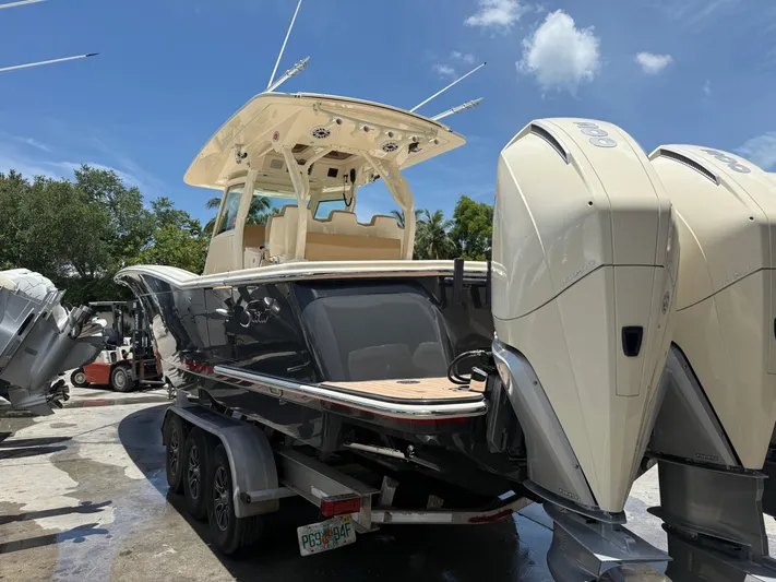  Yacht Photos Pics 2020 Scout 355 LXF boat with dual engines on a trailer, under a clear blue sky.