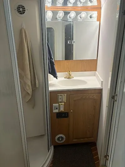  Yacht Photos Pics 1969 Hatteras 45 Sportfish bathroom with wood cabinetry and mirrored vanity.