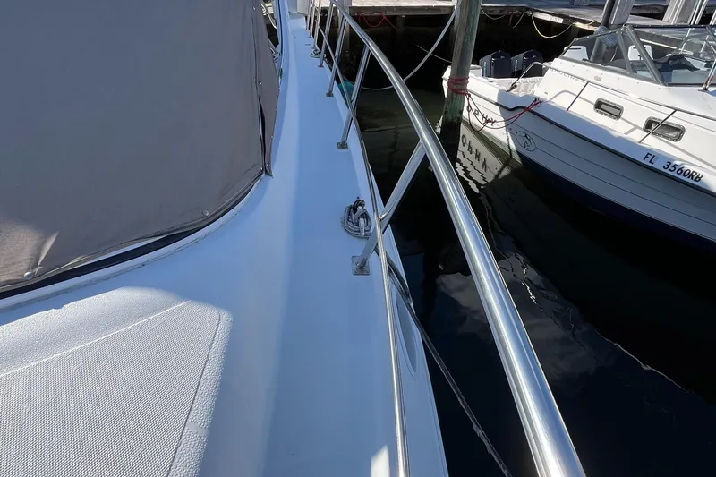 Two Can Do It Yacht Photos Pics 2000 Cruisers Yachts 4450 docked, showcasing sleek deck and railing design.