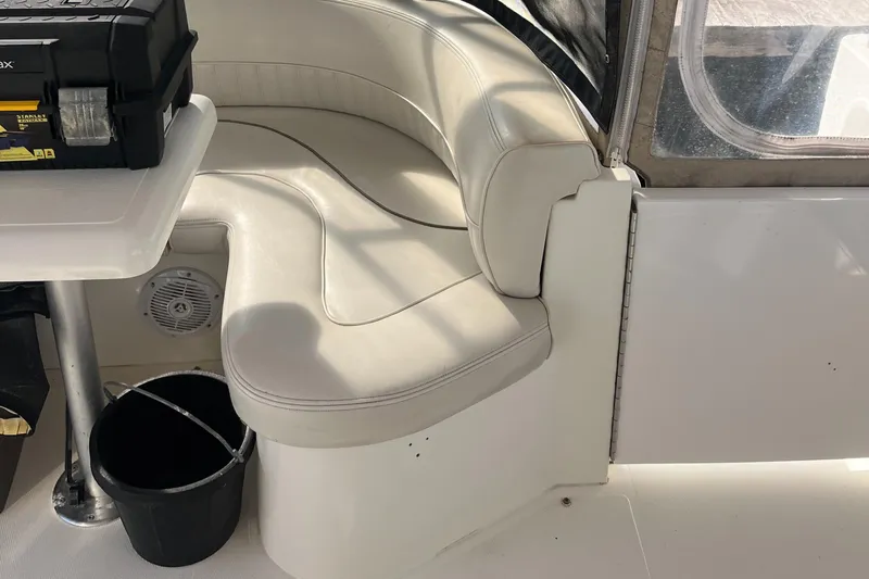 Two Can Do It Yacht Photos Pics Interior seating of 2000 Cruisers Yachts 4450 with white upholstery and storage box.