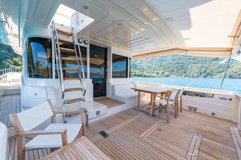 Jasmine 3 Yacht Photos Pics Luxurious 2011 Apreamare Maestro 65 yacht deck with seating, table, and scenic water view.