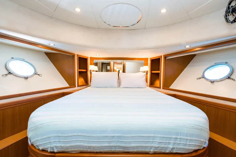 Jasmine 3 Yacht Photos Pics Luxurious bedroom interior of 2011 Apreamare Maestro 65 yacht with portholes and cozy lighting.