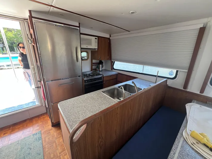 Sunset Cay Yacht Photos Pics Interior of 2004 Endeavour Explorer 46 PowerCat kitchen with stainless steel appliances and wood finish.