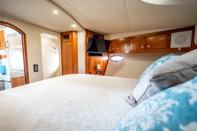 Lunasea Yacht Photos Pics Luxurious 2005 Cruiser Yachts 405 EXPRESS cabin with elegant wood finishes and cozy bedding.