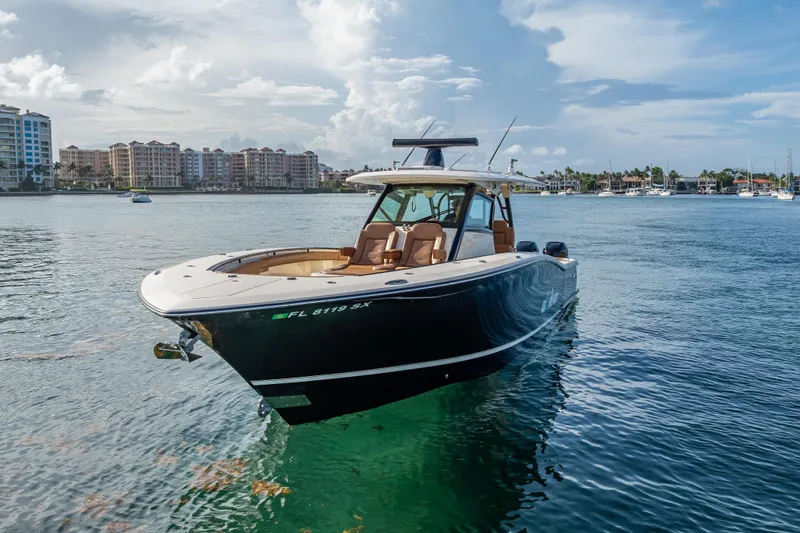  Yacht Photos Pics 2021 Scout 380 LXF boat on calm water with cityscape background.